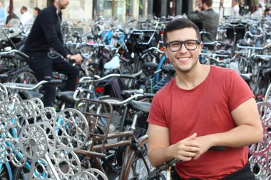 Amsterdam 'da bisiklet parkındaki yakışıklı genç adamın yakın plan portresi.