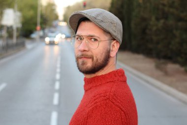 Akşam sokakta şık giyinmiş yakışıklı genç adamın yakın plan portresi.