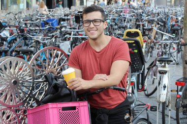 Amsterdam 'da bisiklet parkındaki yakışıklı genç adamın yakın plan portresi.