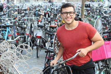 Amsterdam 'da bisiklet parkındaki yakışıklı genç adamın yakın plan portresi.