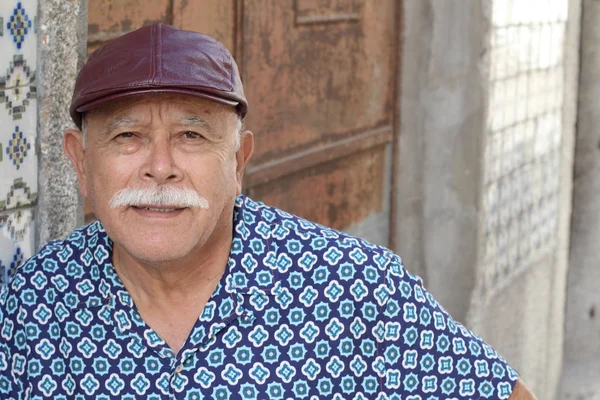 Senior Hispanic man wearing hat, outdoor portrait