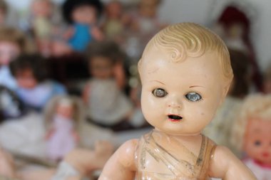 Havuzun arkasında oyuncağı olan mavi elbiseli küçük kız.