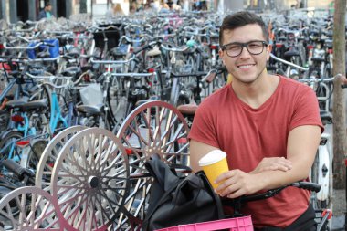 Amsterdam 'da bisiklet parkındaki yakışıklı genç adamın yakın plan portresi.