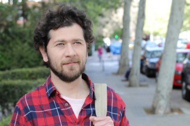 Sokakta şık giyinmiş yakışıklı bir gencin yakın plan portresi.