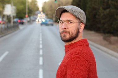 Akşam sokakta şık giyinmiş yakışıklı genç adamın yakın plan portresi.