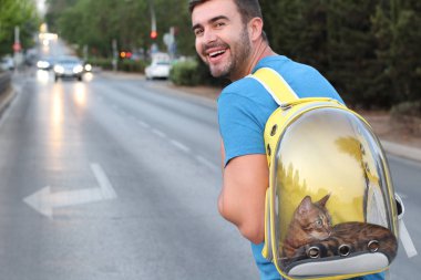 Kedisini baloncuklu sırt çantasında taşıyan sevimli bir adam.