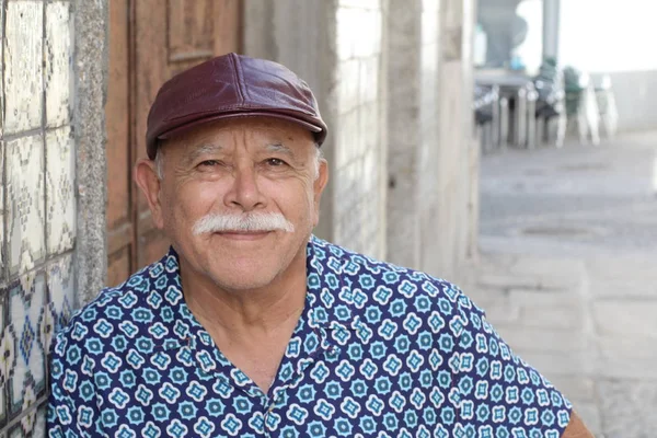 Senior Hispanic man wearing hat, outdoor portrait