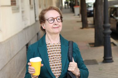 Bir fincan kahveyle takım elbiseli genç bir kadının portresi.