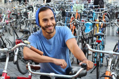 Eski Avrupa şehrinde bisiklet parkındaki yakışıklı genç adamın yakın plan portresi.