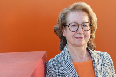 Alışveriş torbalarıyla gülümseyen yaşlı bir kadının portresi.