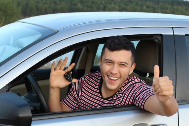 Çekici bir adam araba kullanıyor, yakın plan bir portre.