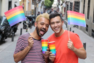 Igbt bayrakları ve bardakları sokaktaki lgbt bayrağı renginde eşcinsel bir çiftin yakın plan portresi.