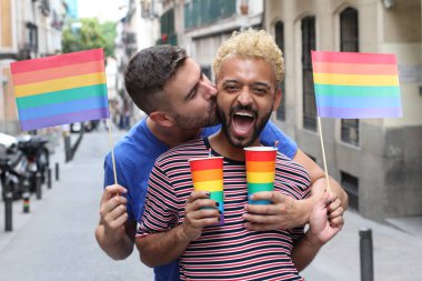 Igbt bayrakları ve bardakları sokaktaki lgbt bayrağı renginde eşcinsel bir çiftin yakın plan portresi.