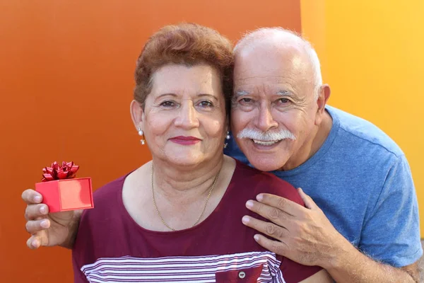 Hispânico Sênior Surpreendendo Seu Ente Querido Com Presente — Fotografia de Stock