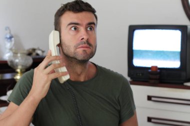 Evde telgrafla konuşan yakışıklı genç adamın yakın plan portresi.