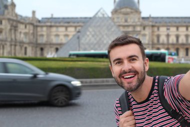 Paris, Fransa 'daki Louvre Müzesi' nin önündeki yakışıklı genç adamın yakın plan portresi.