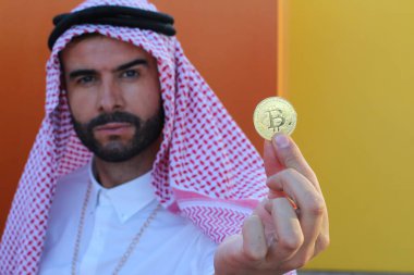 Sokakta Bitcoin tutan yakışıklı Arap adamın yakın plan portresi.