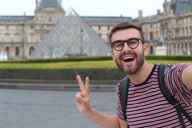 Paris, Fransa 'daki Louvre Müzesi' nin önündeki yakışıklı genç adamın yakın plan portresi.