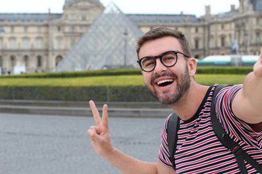 Paris, Fransa 'daki Louvre Müzesi' nin önündeki yakışıklı genç adamın yakın plan portresi.