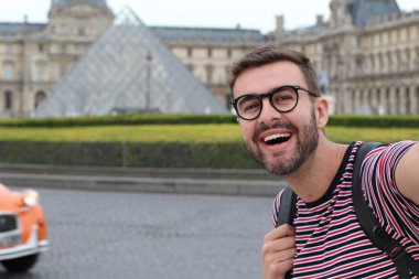 Paris, Fransa 'daki Louvre Müzesi' nin önündeki yakışıklı genç adamın yakın plan portresi.