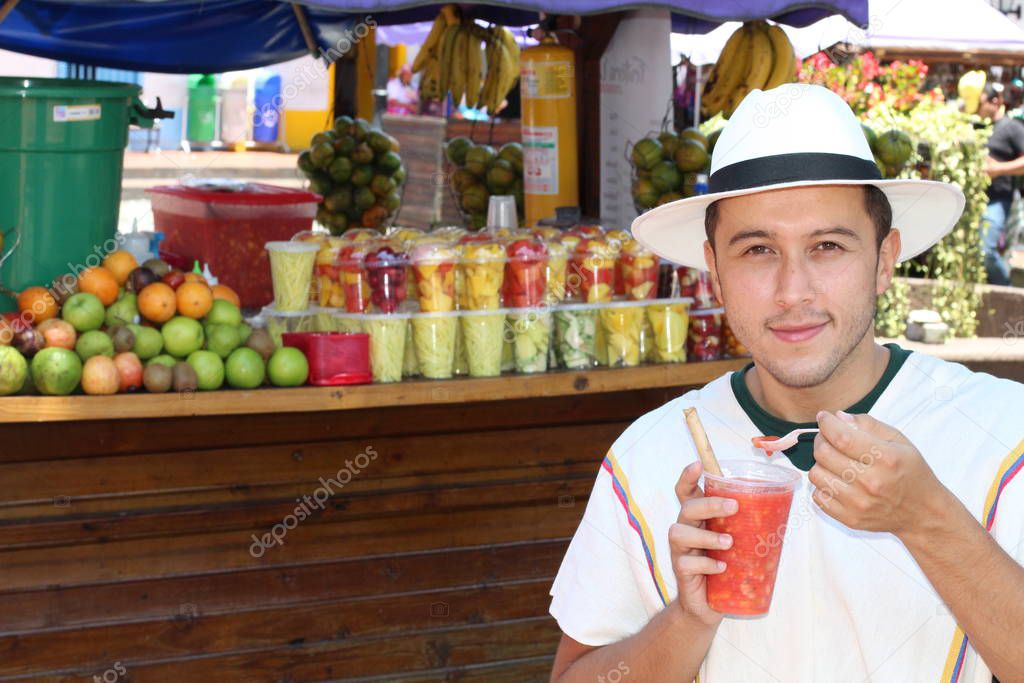 Ethnic man eating assorted fresh sliced fruits