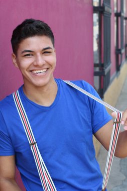 Yakından bakınca şık giyinen, sokakta pantolon askısı takan yakışıklı bir genç resmi var.