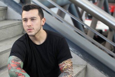 Sokakta sahte dövme kolları olan yakışıklı bir gencin yakın plan portresi.