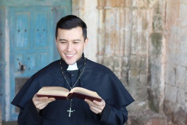 Kilise geçmişinde elinde açık İncil tutan cüppeli bir rahip.