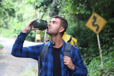Doğada sırt çantasıyla gezen yakışıklı bir gencin yakın plan portresi.