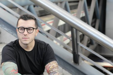 Sokakta sahte dövme kolları olan yakışıklı bir gencin yakın plan portresi.