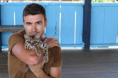 Handsome man holding a baby ocelot clipart