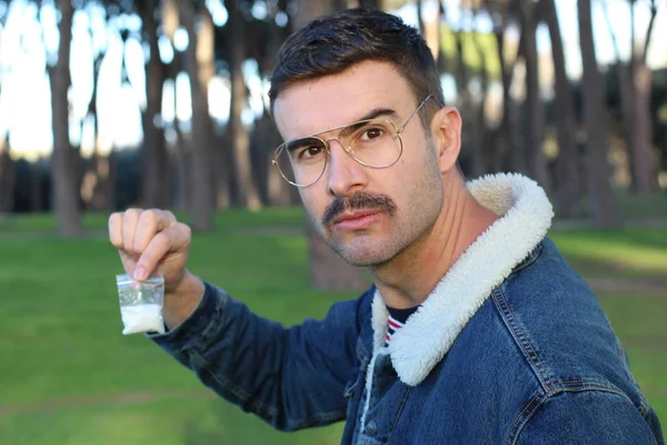 Mężczyzna Okularach Pokazuje Paczkę Narkotykami Stojącą Parku — Zdjęcie stockowe