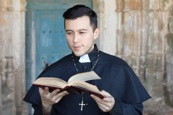 Красивый Священник Рясе Читает Библию Церковном Фоне — стоковое фото