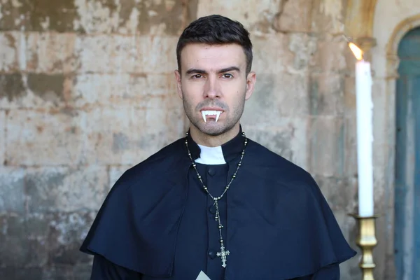 Vampire priest posing on church background