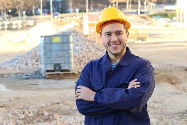 Young Smiling Worker Helmet Standing Folded Hands Construction Background — 스톡 사진