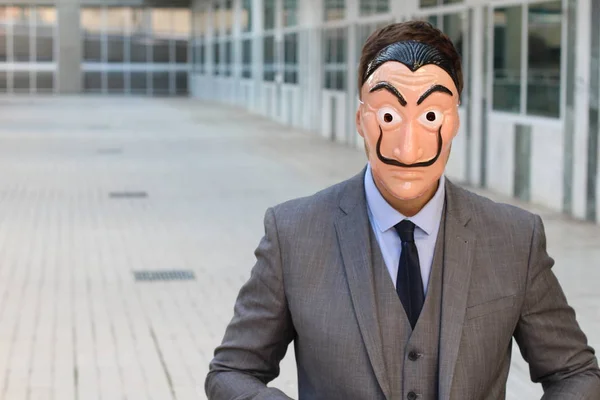 Elegant businessman with wearing mask standing outdoors at daytime