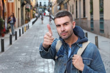 Sokakta kameraya bakan yakışıklı genç adamın yakın plan portresi.