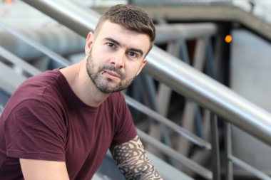 Sokakta şık giyinmiş yakışıklı bir gencin yakın plan portresi.