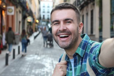 Yakından bakınca, sokakta ekose gömlekli yakışıklı bir adamın portresi.