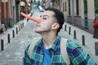 Sokakta uzun burunlu, sıradan giysili yakışıklı genç adamın yakın plan portresi.