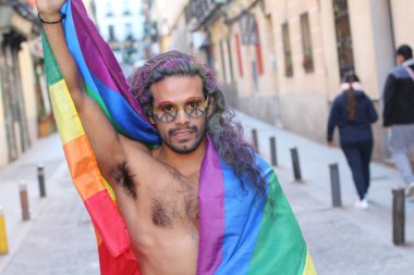 Sokakta Igbt bayrağı taşıyan yakışıklı, üstsüz, eşcinsel bir adamın yakın plan portresi.