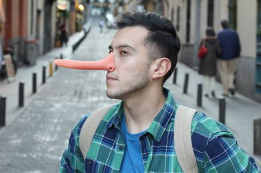 Sokakta uzun burunlu, sıradan giysili yakışıklı genç adamın yakın plan portresi.