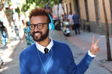 Sokaklarda kulaklıkla müzik dinleyen yakışıklı bir gencin yakın plan portresi.