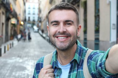 Yakından bakınca, sokakta ekose gömlekli yakışıklı bir adamın portresi.