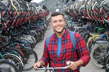 Bisikletli otoparktaki neşeli etnik adam.