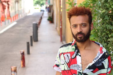 Caddedeki renkli gömlekli yakışıklı genç adamın yakın plan portresi.