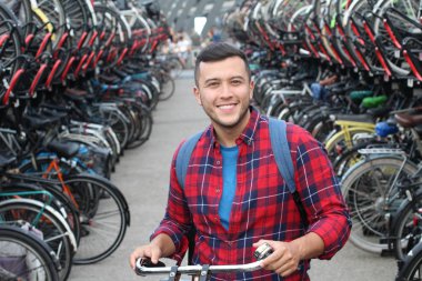 Bisikletli otoparktaki neşeli etnik adam.