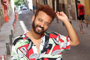 Caddedeki renkli gömlekli yakışıklı genç adamın yakın plan portresi.