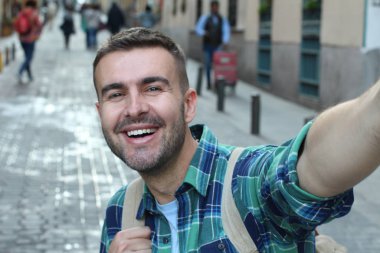 Yakından bakınca, sokakta ekose gömlekli yakışıklı bir adamın portresi.