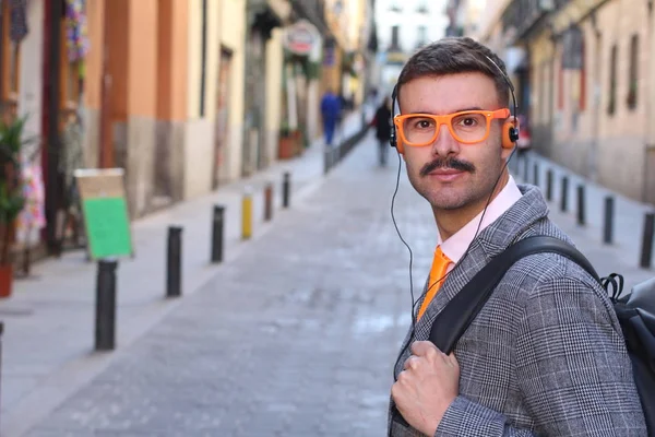 路上でヘッドフォンや眼鏡をかけたジャケット姿のハンサムな青年のクローズアップ肖像画 — ストック写真